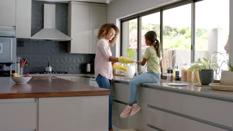 Madre-Birracial-E-Hija-Lavando-Y-Secando-Platos-En-La-Cocina,-Espacio-Para-Copiar,-Cámara-Lenta