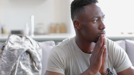 Worried-african-american-male-soldier-sitting-and-thinking-in-sunny-living-room,-slow-motion