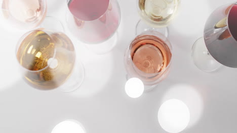 Composite-of-glasses-of-white,-rose-and-red-wine-over-white-background