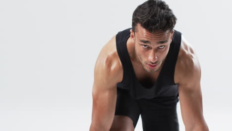 Focused-young-biracial-man-athlete-in-athletic-wear-ready-for-a-workout-on-a-white-background