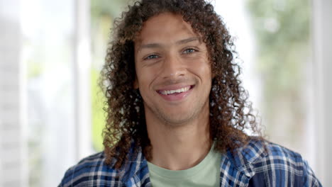 Retrato-De-Un-Hombre-Birracial-Feliz-Con-El-Pelo-Largo-Y-Rizado-Sonriendo-En-Casa,-Cámara-Lenta