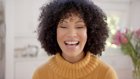 Portrait-of-happy-african-american-woman-with-curly-hair-at-home,-slow-motion