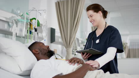 Diverse-female-doctor-and-male-patient-talking-in-hospital-room,-slow-motion