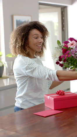 Video-Vertical-De-Una-Mujer-Birracial-Feliz-Teniendo-Videollamada-Con-Teléfono-Inteligente-El-Día-De-San-Valentín,-Cámara-Lenta