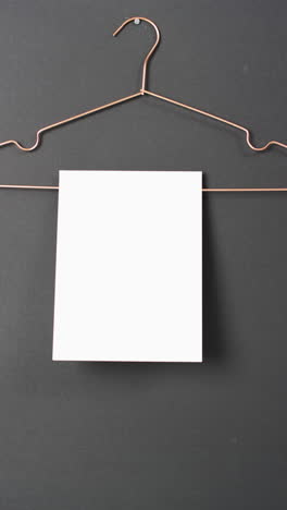 Vertical-video-of-book-with-white-blank-pages-on-hanger-and-copy-space-on-black-background