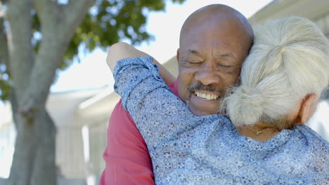 Feliz-Pareja-Birracial-Mayor-Abrazándose-En-El-Soleado-Jardín-De-Casa,-Cámara-Lenta