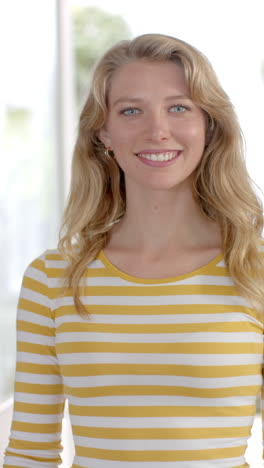 Vertical-video-of-portrait-of-caucasian-woman-with-blond-hair-at-home,-slow-motion