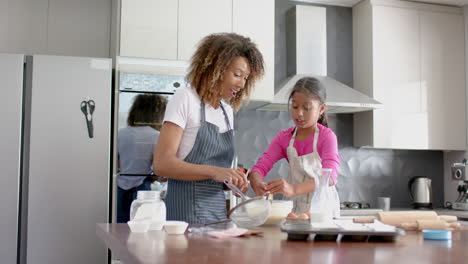 Feliz-Madre-Birracial-E-Hija-Haciendo-Mezcla-De-Pasteles,-Horneando-En-La-Cocina,-Cámara-Lenta