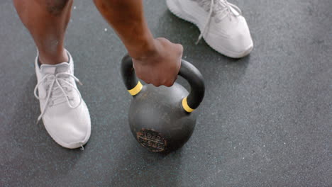 Un-Hombre-Afroamericano-En-Forma-Agarra-Una-Pesa-Rusa-En-El-Gimnasio