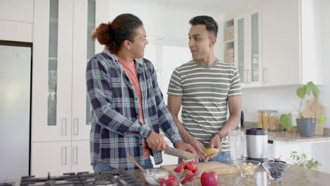 Feliz-Pareja-Gay-Diversa-Cortando-Fruta-Para-Un-Batido-Saludable-En-La-Cocina,-Cámara-Lenta