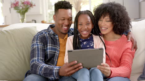 Portrait-of-happy-african-american-mother-with-daughter-using-tablet-at-home,-slow-motion