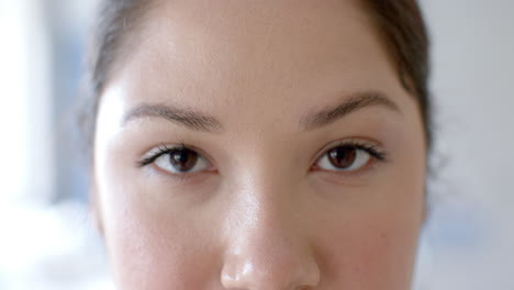 Portrait-of-close-up-of-brown-eyes-of-caucasian-female-doctor-smiling-in-hospital,-slow-motion