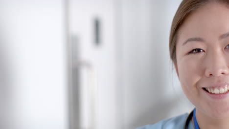 Young-Asian-nurse-smiles-warmly-in-a-bright-hospital-setting-with-copy-space