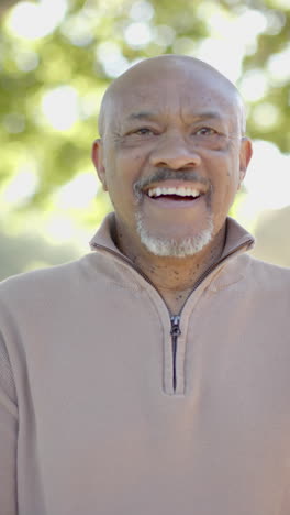 Vertical-video-of-portrait-of-happy-senior-biracial-man-at-balcony,-slow-motion