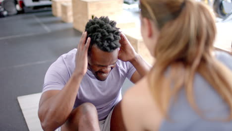 Fit-African-American-man-exercising-at-the-gym-with-a-trainer