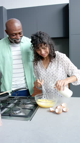 Feliz-Pareja-Madura-Diversa-Abrazando-Y-Preparando-Huevos-En-La-Cocina-De-Casa,-Copiando-Espacio,-Cámara-Lenta