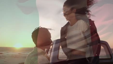 Animation-of-flag-of-italy-over-happy-diverse-couple-embracing-by-car-on-sunset-beach