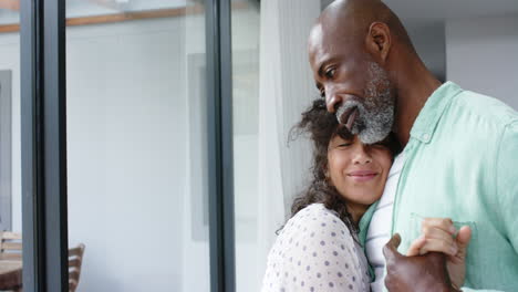 Happy-biracial-couple-holding-hands-and-dancing-in-living-room,-slow-motion