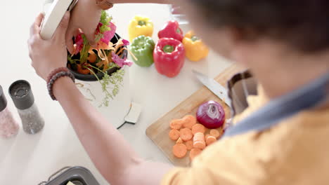 Biracial-man-wearing-apron-and-throwing-waste-out-in-kitchen,-slow-motion