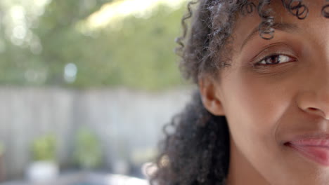 Retrato-De-Una-Mujer-Birracial-Feliz-Con-El-Pelo-Rizado-En-El-Jardín,-Espacio-Para-Copiar,-Cámara-Lenta