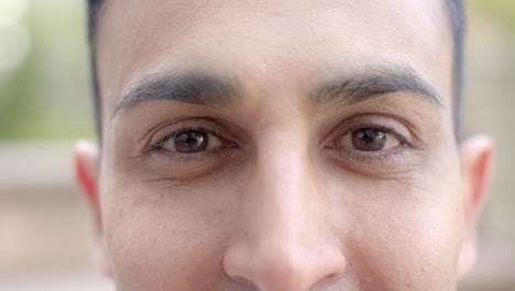 Portrait-close-up-of-eyes-of-happy-biracial-man-smiling-in-sunny-garden,-slow-motion