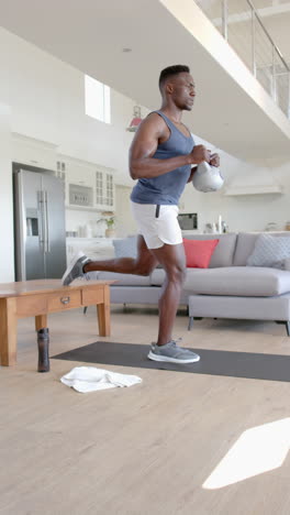 Focused-african-american-man-exercising-with-kettlebell-in-sunny-living-room,-slow-motion