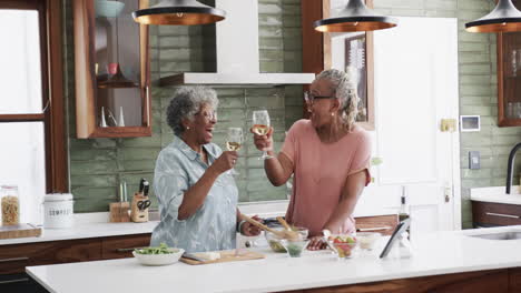 Amigas-Afroamericanas-Mayores-Cocinando-Y-Bebiendo-Vino-En-La-Cocina,-Espacio-Para-Copiar,-Cámara-Lenta