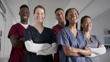 Portrait-of-happy-diverse-male-and-female-doctors-wearing-scrubs-in-hospital,-slow-motion