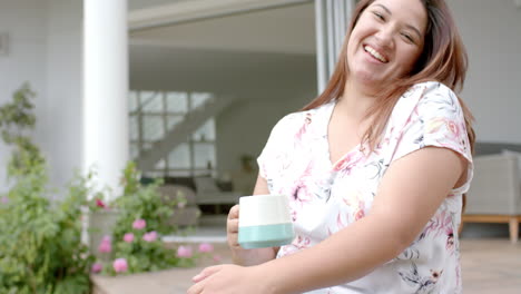 Übergroße,-Gemischtrassige-Frau,-Die-Auf-Der-Terrasse-Sitzt,-Kaffee-Trinkt-Und-Lacht,-Platz-Zum-Kopieren,-Zeitlupe