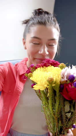 Vertikales-Video-Eines-Glücklichen,-Gemischtrassigen-Teenager-Mädchens-Mit-Blumen-Beim-Videoanruf,-Zeitlupe