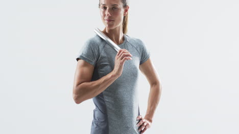 Young-Caucasian-woman-holds-a-baton-confidently-on-a-white-background