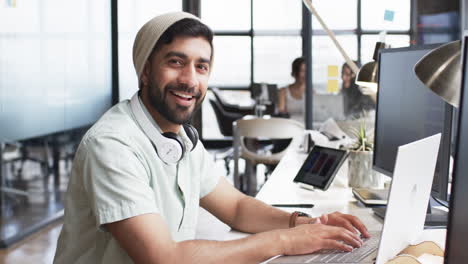 Un-Joven-Con-Barba-Trabajando-En-Una-Computadora-En-Una-Oficina-Moderna-Para-Su-Negocio.