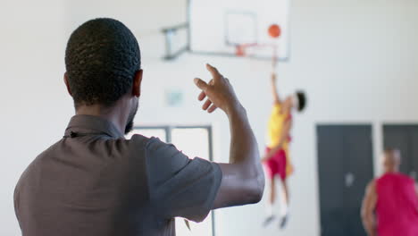 Entrenador-Afroamericano-Entrena-Baloncesto-En-Un-Gimnasio