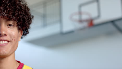 Young-biracial-man-smiles-in-a-gym,-with-copy-space