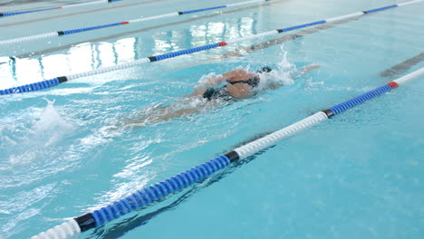 Caucasian-female-swimmer-athlete-swimming-in-a-pool