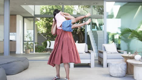 Biracial-grandmother-in-a-coral-dress-embraces-a-young-biracial-granddaughter