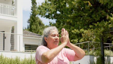 Senior-biracial-woman-meditates-in-a-tranquil-outdoor-setting