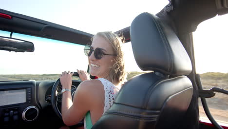 Una-Joven-Caucásica-Disfruta-De-Un-Paseo-Soleado-En-Un-Convertible-En-Un-Viaje-Por-Carretera