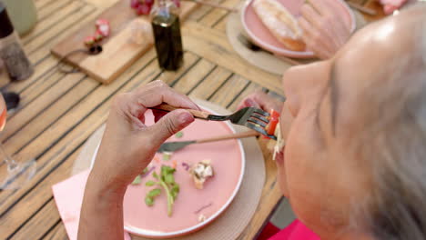 Senior-biracial-woman-enjoys-a-meal-outdoors