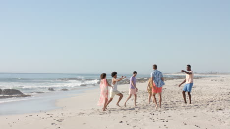 Verschiedene-Freunde-Genießen-Eine-Partie-Fußball-An-Einem-Sonnigen-Strand-Mit-Platz-Zum-Kopieren