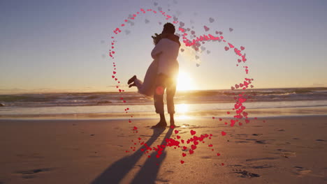 Animation-of-hearts-over-happy-diverse-just-married-couple-dancing-on-beach-by-sea