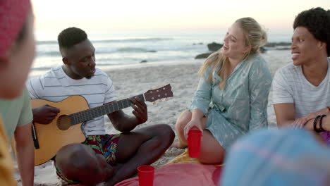 Un-Joven-Afroamericano-Toca-La-Guitarra-En-La-Playa-En-Una-Fiesta.