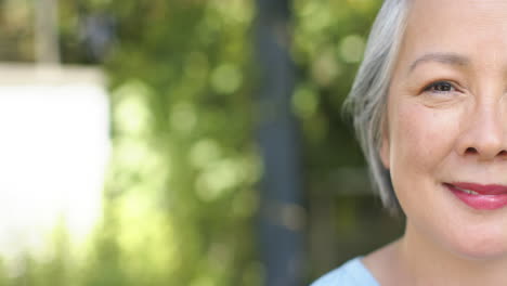 Close-up-of-a-smiling-senior-Asian-woman-outdoors,-with-copy-space