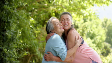 Mujeres-Mayores-Caucásicas-Y-Asiáticas-Comparten-Un-Alegre-Abrazo-Al-Aire-Libre