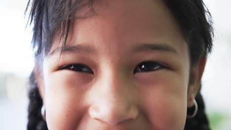 Close-up-of-a-biracial-girl-with-a-subtle-smile-and-dark-eyes