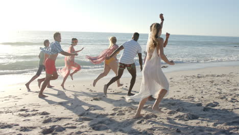 Verschiedene-Freunde-Genießen-Einen-Lebhaften-Lauf-Am-Strand