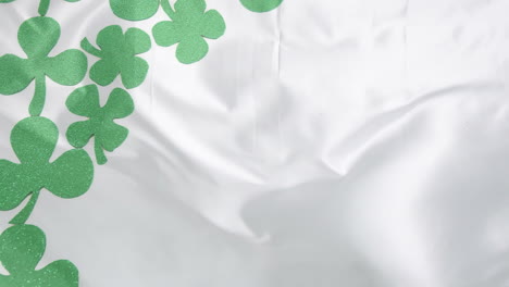 Animation-of-shamrocks-falling-over-white-background