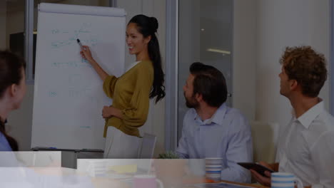 Animation-of-globe-with-breaking-news-text-over-diverse-colleagues-discussing-work