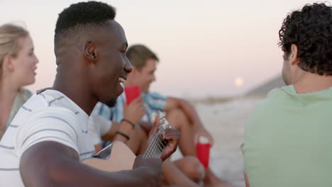 Un-Joven-Afroamericano-Toca-La-Guitarra-En-Una-Reunión-En-La-Playa-En-Una-Fiesta