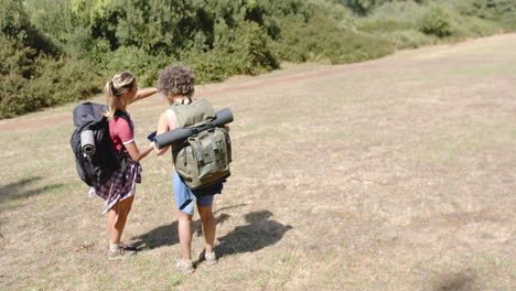 Zwei-Frauen-Mit-Rucksäcken-Wandern-Auf-Einer-Sonnigen-Wiese-Mit-Platz-Zum-Kopieren